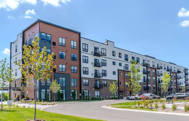 A modern apartment complex with a mix of brick and white buildings.