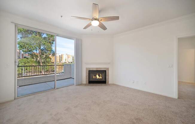 A living room with a fireplace and a ceiling fan.