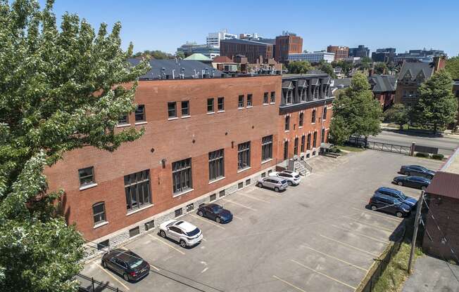 an aerial view of a brick building in a parking lot at The Knights @ 506 Delaware Apartments, Buffalo, New York