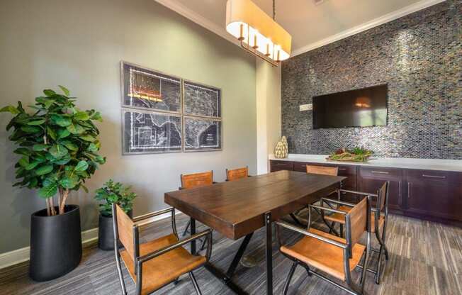 a dining room with a table and chairs and a tv on the wall