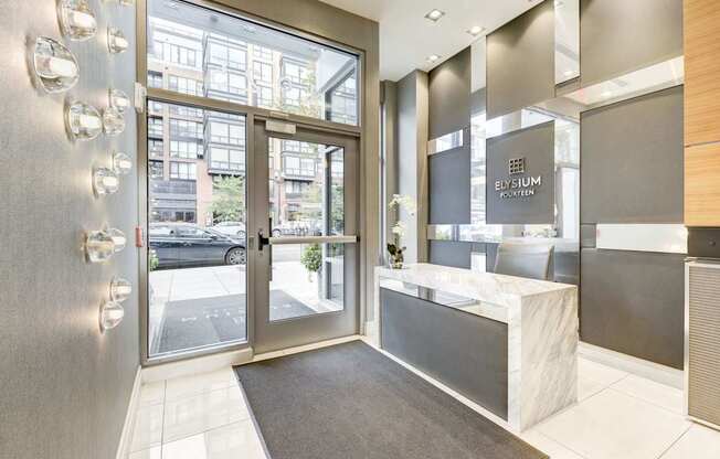 A modern front desk with a glass door leading to a balcony.