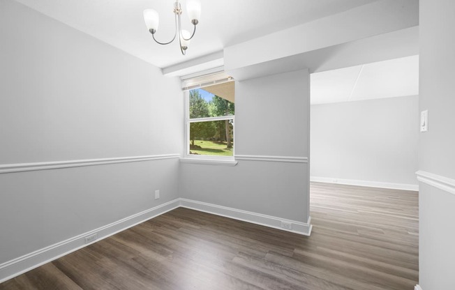 an empty room with white walls and a window