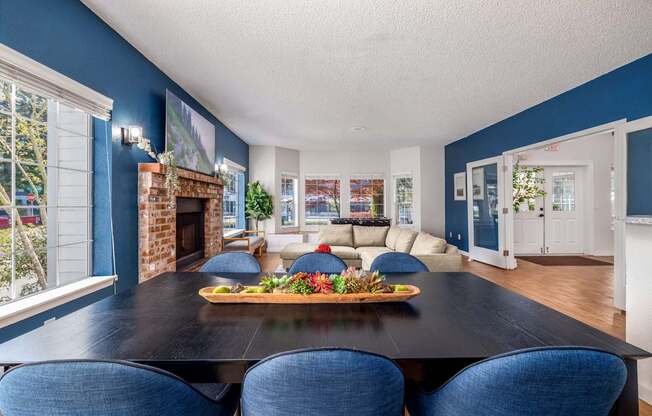 A dining room with a black table and blue chairs.