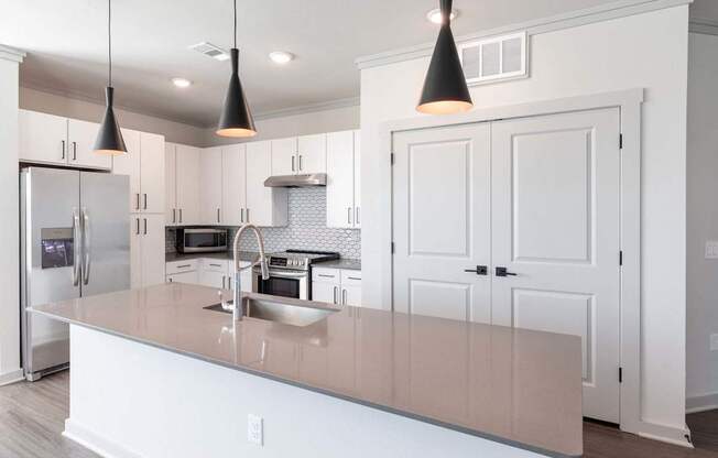 A kitchen with a white counter and cabinets.