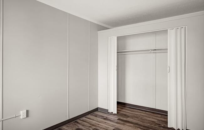 an empty room with white walls and a sliding closet door