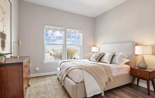 a bedroom with a bed and two windows at Metro 303, Hempstead, NY