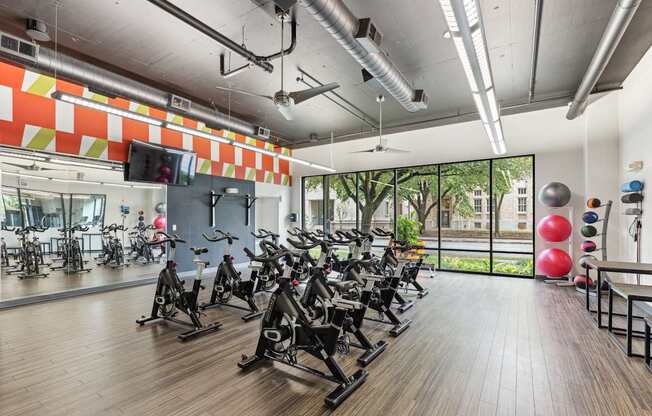 A gym with a row of stationary bikes and a balloon on the right.