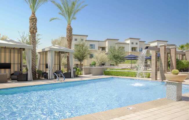 A pool surrounded by palm trees and lounge chairs.