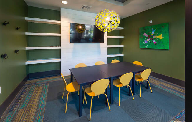 a dining room with a black table and yellow chairs