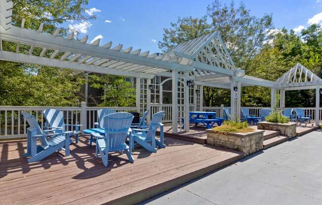 a patio with blue chairs and a white pavilion