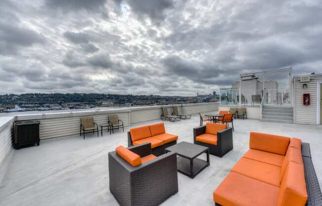 Rooftop Seating Area with Orange Chairs, Sofas and View of City