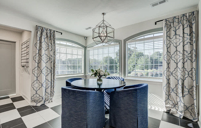 A dining room with a round table and chairs.