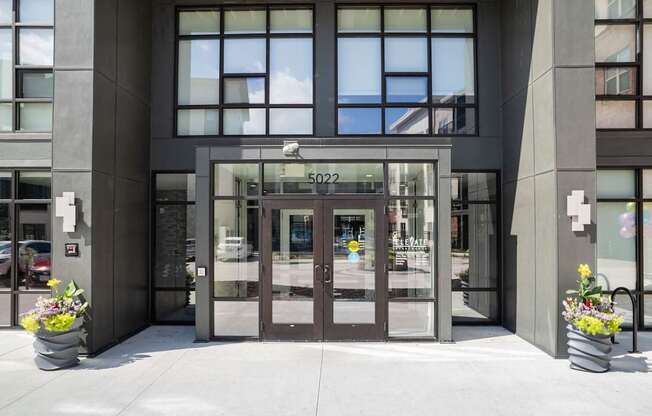 The image shows the front of a building with a glass door and a sign that reads 5022.
