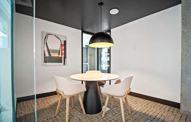 A glass table with four chairs around it.