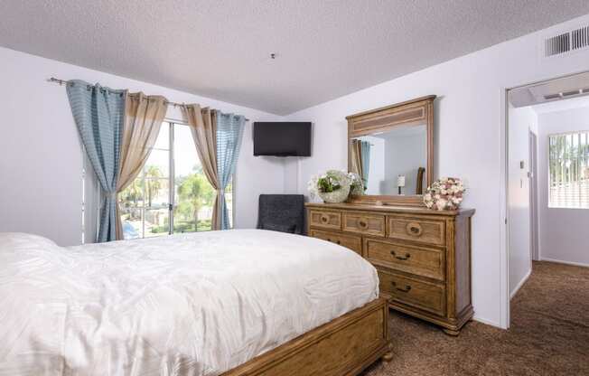 a bedroom with a bed and a dresser and a window