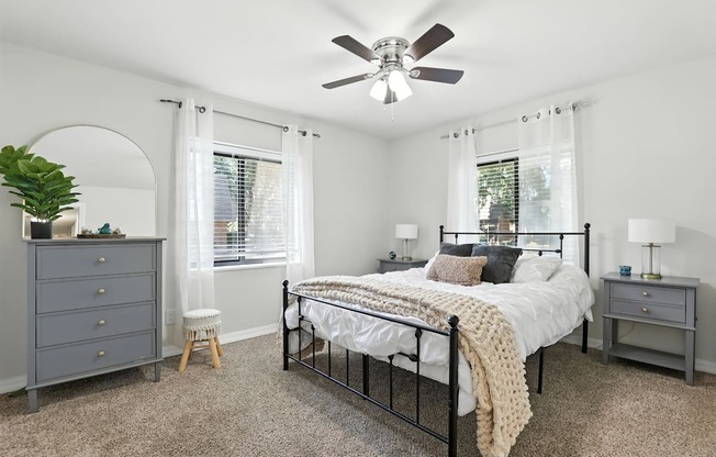 A bedroom with a bed, dresser, and window.