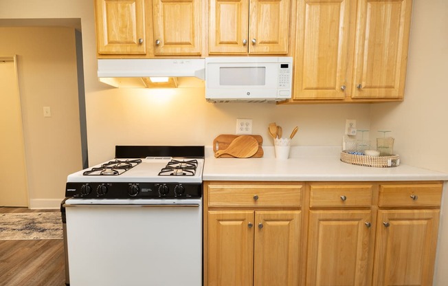 a kitchen with a stove and microwave and wooden cabinets