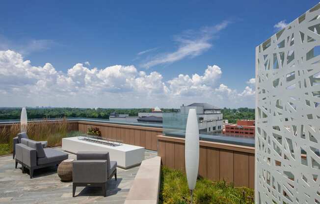 a roof deck with a fire pit and a view of the city