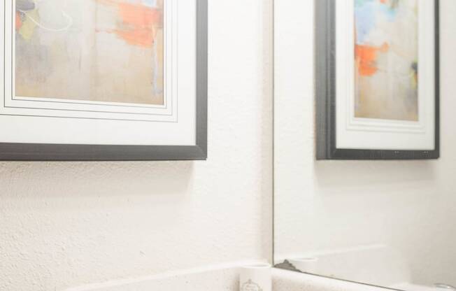 a bathroom with a sink and two paintings on the wall