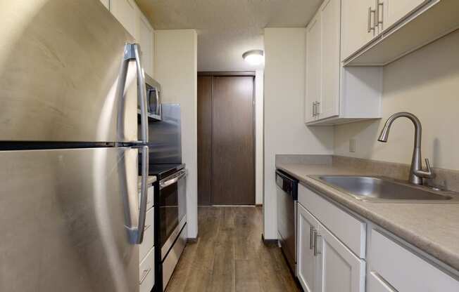 a kitchen with white cabinets and stainless steel appliances