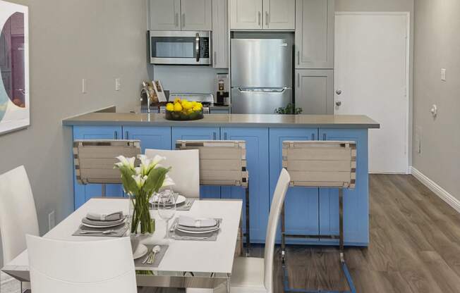 a kitchen and dining room with blue cabinets and a table and chairs