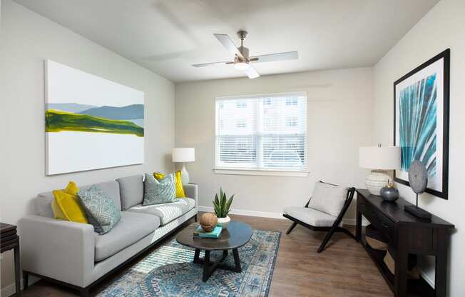 a living room with a couch chair and coffee table at 55 Fifty at Northwest Crossing, Houston, TX 77092