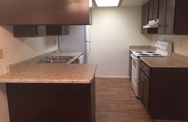 an empty kitchen with a stove and a sink