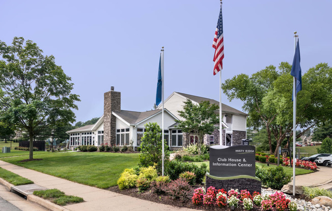 a building with an american flag and a sign in front of it at Misty Ridge Apartments, Virginia