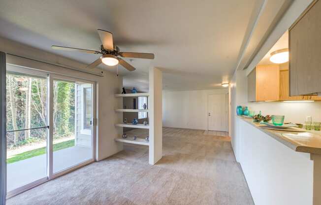 a kitchen and living room with a ceiling fan and a window