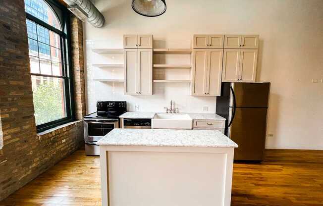 A kitchen with a white island and wooden floors.
