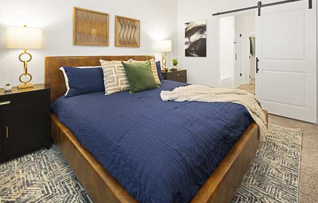 a bedroom with a large bed with blue blankets and pillows at Aura Vegas Apartments, Nevada, 89103