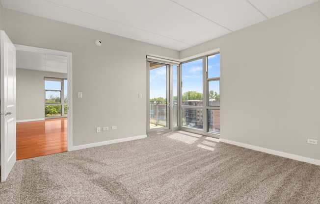 an empty living room with sliding glass doors to a balcony