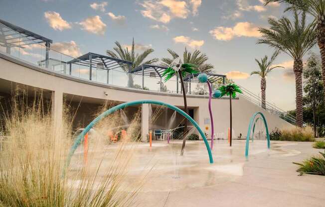 A water park with a fountain and palm trees.