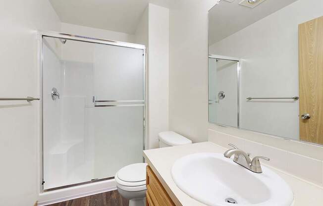 A white sink is on a countertop next to a toilet.