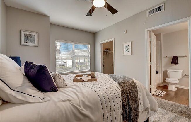 a bedroom with a bed and a ceiling fan