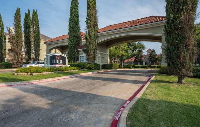 The entrance to a hotel with a red archway and a sign that says