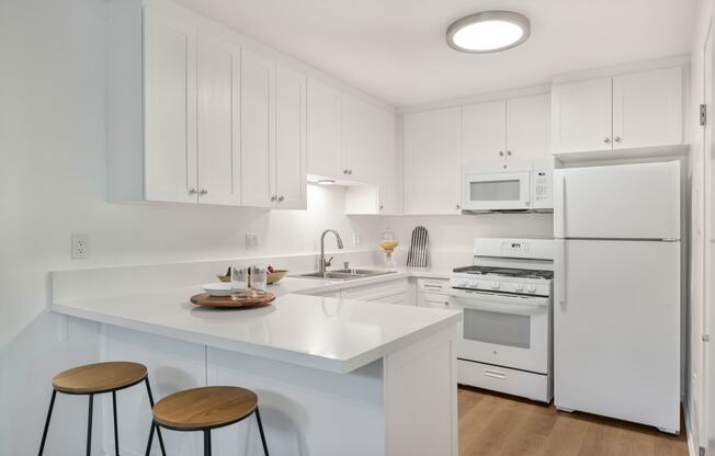 a kitchen with a white counter top and white appliances