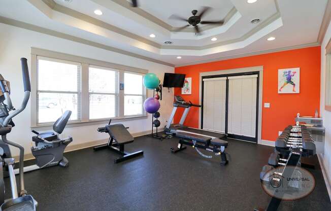 a workout room with exercise equipment and a ceiling fan