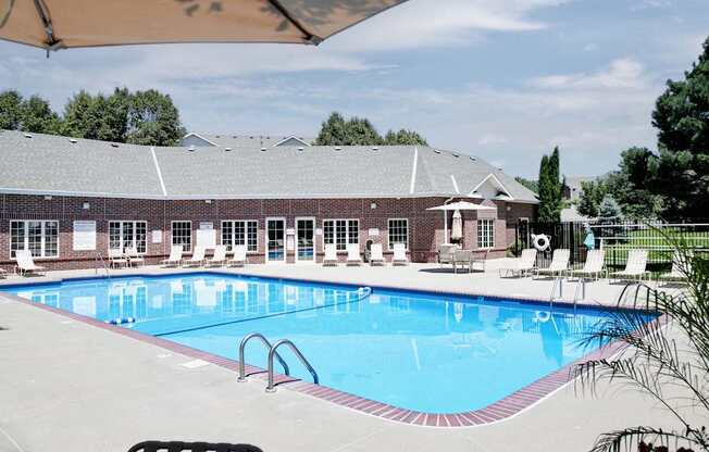 A large swimming pool in front of a building with a covered seating area. at Tranquility Pointe, Nebraska, 68164