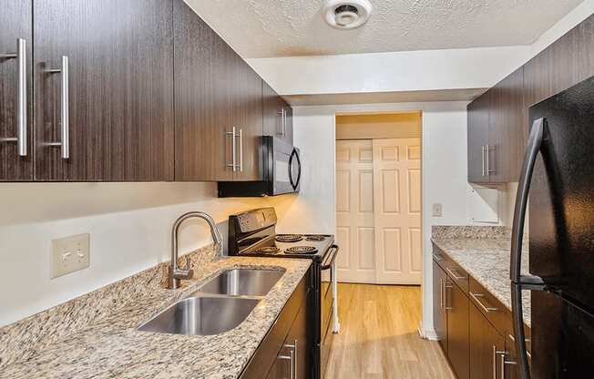 a kitchen with wood cabinets and granite counter tops and a sink