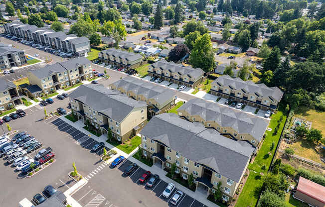 A bird's eye view of a residential area with multiple houses and a parking lot.