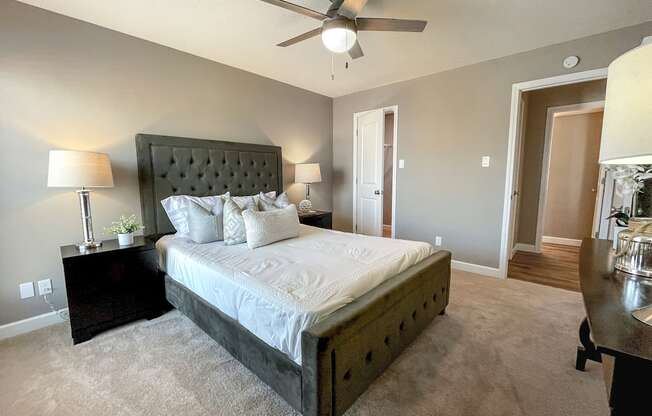 a bedroom with a large bed and a ceiling fan