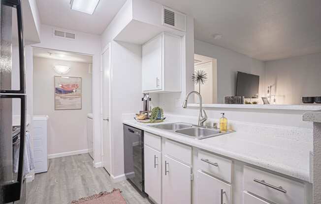 a kitchen with white cabinets and a stainless steel sink