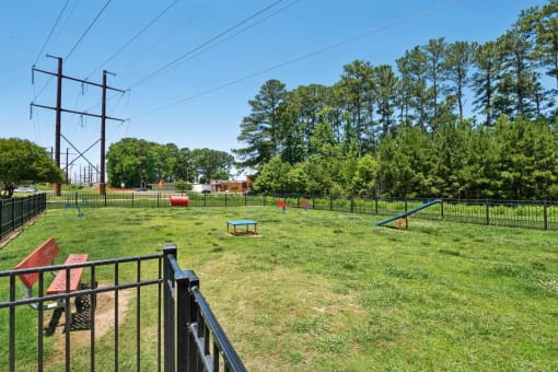 a fenced in backyard with a dog park and a picnic table