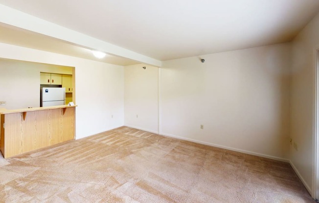 the living room and kitchen of an empty apartment
