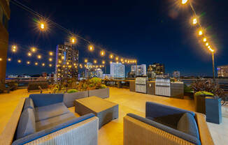 a roof top bar with a view of the city at night