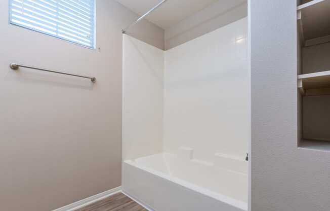 a bathroom with a white tub and a window