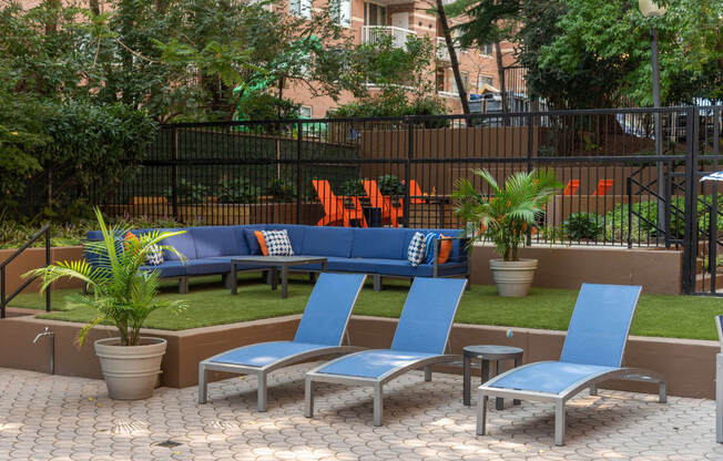 a seating area with blue chairs and a lawn