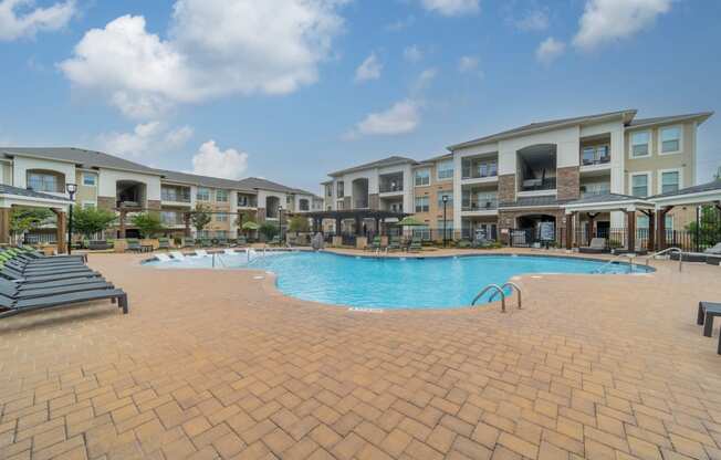 a large swimming pool in front of an apartment building