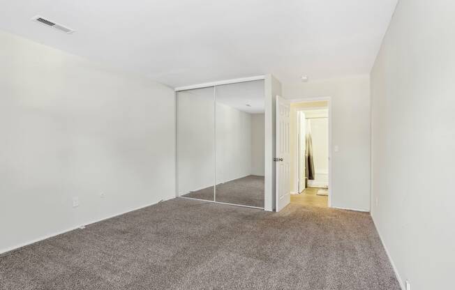 A room with a carpeted floor and a glass door.